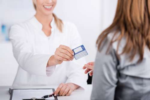 Foto: Patientin und Arzthelferin mit Versicherungskarte 